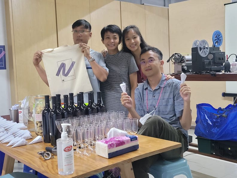 Four people pose with party favors and film projectors visible in the background