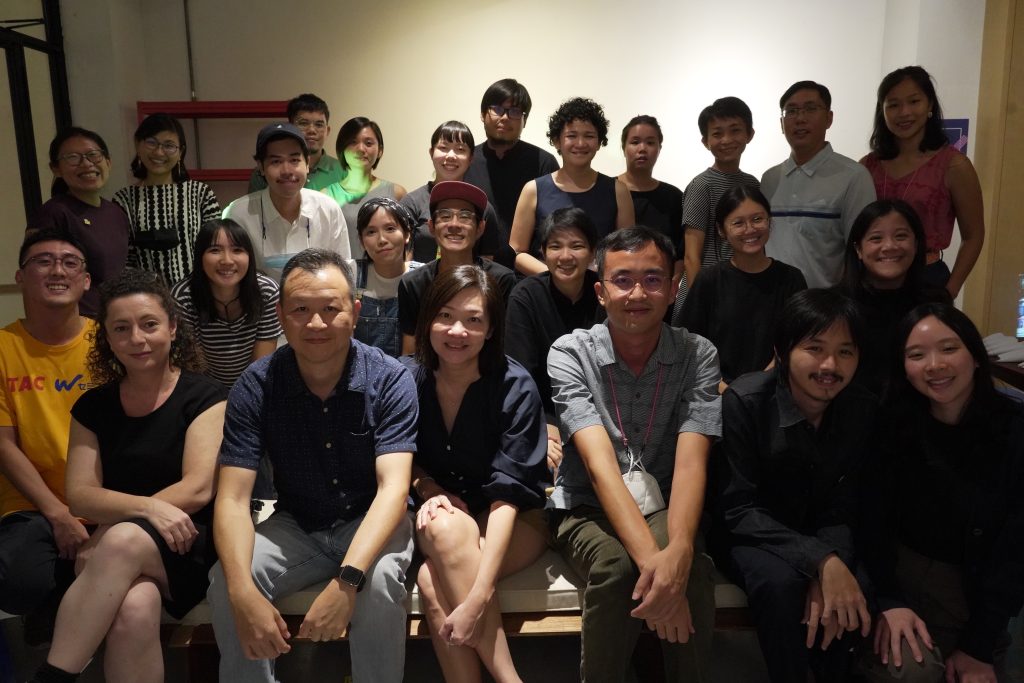 A group of about 15 people pose smiling for the camera